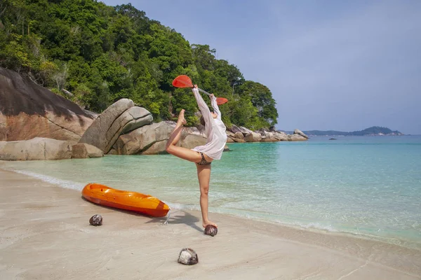 Joyeux jeune fille à côté d'un kayak équilibrage avec une rame sur un le — Photo