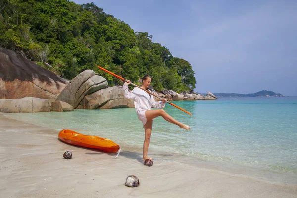 Joyeux jeune fille à côté d'un kayak équilibrage avec une rame sur un le — Photo