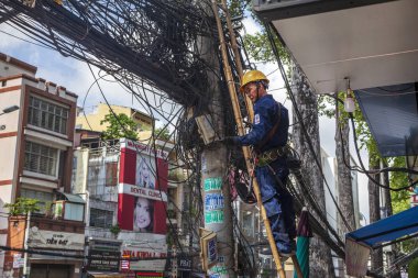 Bir teknisyen dağınık elektrik ağını tamir ediyor veya kontrol ediyor