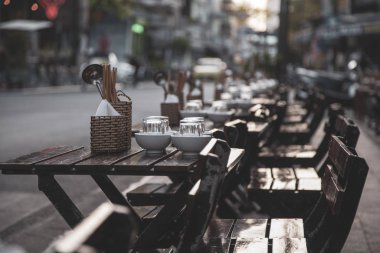 Boş masaları olan bir açık hava kafe, ziyaretçiler için hazır, kahverengi t