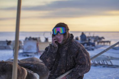  Far North, Yamal Yarımadası, Ren Geyiği Çobanları Günü, Nenets 'in ulusal kıyafetleri içinde yerel halk, Hunter, kamuflaj giysileri giymiş kayak gözlüklü adam.