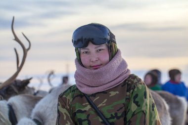  Far North, Yamal Yarımadası, Ren Geyiği Çobanları Günü, Nenets 'in ulusal kıyafetleri içinde yerel halk, ren geyiği yetiştiricisi asistanı, kayak gözlüklü kız ve kamuflaj kıyafeti.