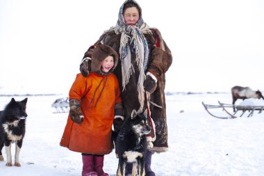 En kuzeyde Yamal, Nenets halkının geçmişi, kuzeydeki insanların evleri, tundrada yurt yakınlarında bir aile fotoğrafı.
