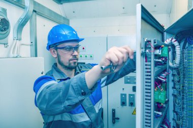 Elektrik ve enerji, elektrik paneli ile çalışan elektromekanik koruma, bir elektrikçi elektrik panelindeki elektrik dağıtım panellerini tanılar,