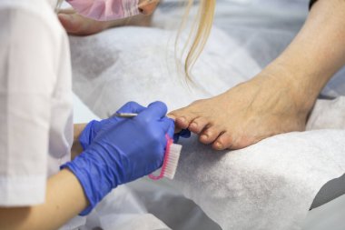 Güzellik salonundaki pedikür uzmanı tarafından yakın plan tırnak bakımı. Pedikür, pedikür için şeffaf tırnak makası..