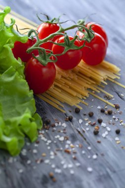Şeri domatesli spagetti ve baharatlı marul, dikey fotoğraf.
