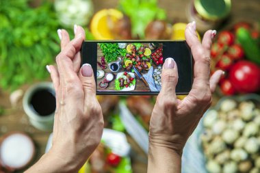 Kızarmış bıldırcın leşleri, portakallı, domatesli, taze maydanozlu ve yakın plan akıllı telefon fotoğraflı ızgarada pişiriliyor.