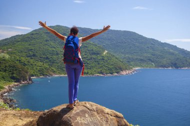 Dağın tepesinde sırt çantalı bir kız Danang Körfezi 'ne bakıyor.