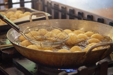 Geleneksel Vietnam tatlıları. Susamlı çörek pişiriyorum, tereyağlı tavada kızartıyorum.