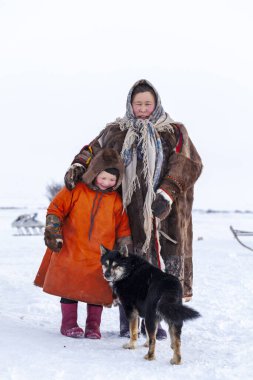 En kuzeyde Yamal, Nenets halkının geçmişi, kuzeydeki insanların evleri, tundrada yurt yakınlarında bir aile fotoğrafı.