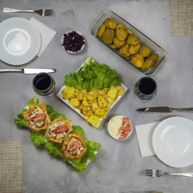 İki kişilik akşam yemeği, karides salatası yapraklı ton balığı salatası sepetleri, fırında patates ve bir bardak şarap, üst manzara, kare resim.