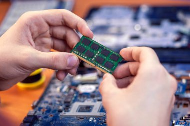 Bilgisayar donanımı, cep telefonu, elektronik, onarım, güncelleme ve teknoloji kavramı. Tamirci bilgisayardaki hafıza kartını değiştirir.
