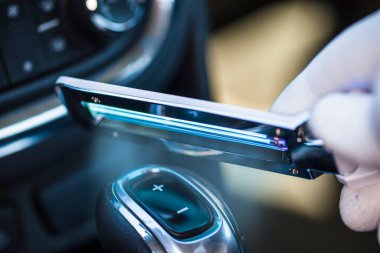 Otomatik şanzıman kabzasının dezenfekte edilmesi, bir dezenfekte cihazı ile, vites kolunda arabada, Covid-19 enfeksiyonunu önler.