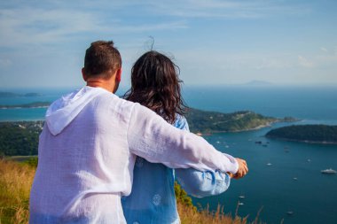 Tayland, Phuket 'teki Nai Harn plajındaki manzara. Genç çift körfez manzarasına bakıyor.
