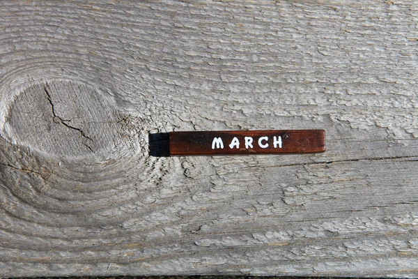 Дерев'яний куб з назвою місяця на старій дошці. березня — стокове фото