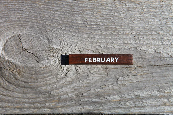 Wooden cube with the name of the month at the old board. Februar — Stock fotografie