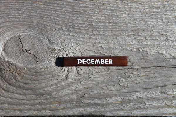 Wooden cube with the name of the month at the old board. Decembe — Stock fotografie