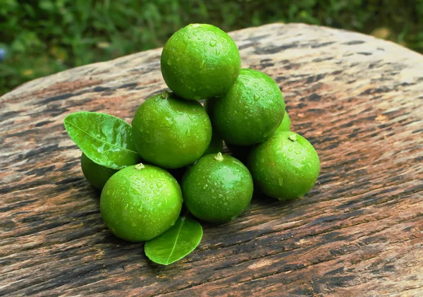 Lemon dengan daun hijau di kayu  . — Stok Foto