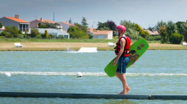 Wakeboarder içine su yürüyüşe yeniden başlatmak için bir duba üzerinde düştü.