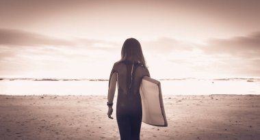 Sahilde yürüyüş bir wetsuit ile giyinmiş kız