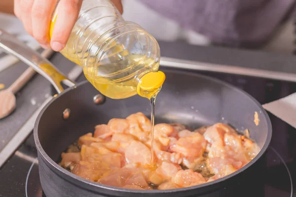 Cocine vertiendo aceite en una cacerola caliente — Foto de Stock