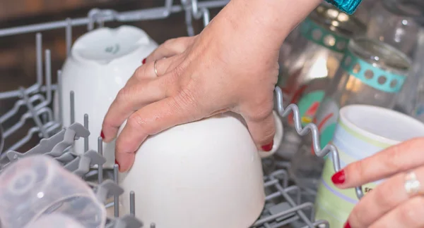 Close-up of a hand filling a dishwasher — Stock Photo, Image