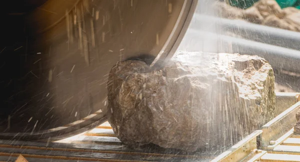 Hombre cortando una piedra con una sierra de agua — Foto de Stock