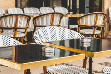 Masalar, sandalyeler ve kül tablası ile Paris Teras