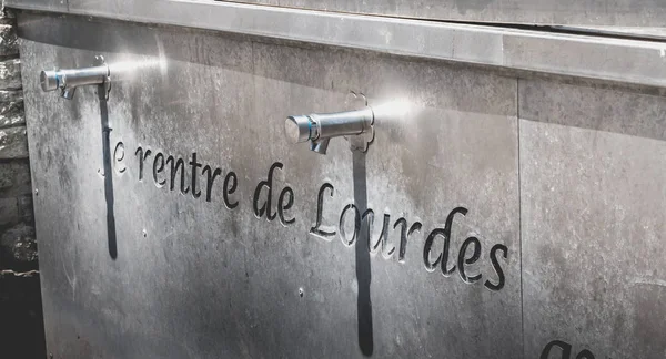 Water spigots to fill bottles of holy water near the grotto of l — Stock Photo, Image