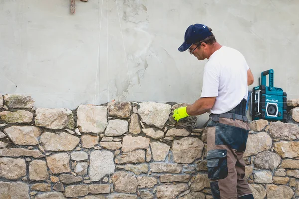 Pedreiro renova uma casa com pedra na tradição de NOIRMOUTI — Fotografia de Stock