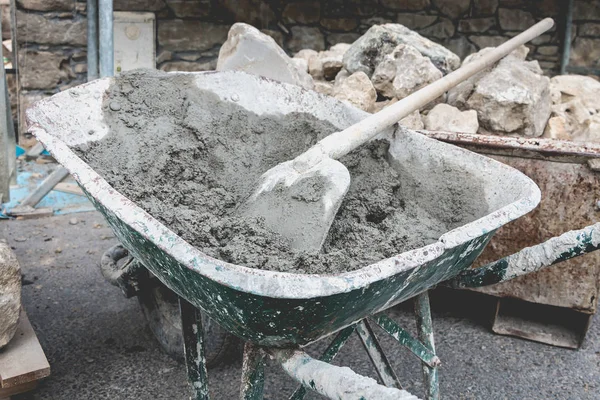 Carrinho de mão cheio de cimento em um projeto de renovação — Fotografia de Stock