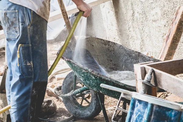 adam bir yenileme projesi üzerinde bir el arabası temizler