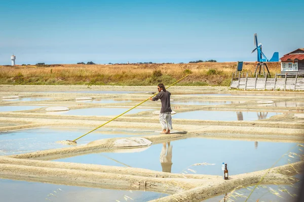 二人の男は、塩性湿地の伝統的な方法で塩を収穫します。 — ストック写真