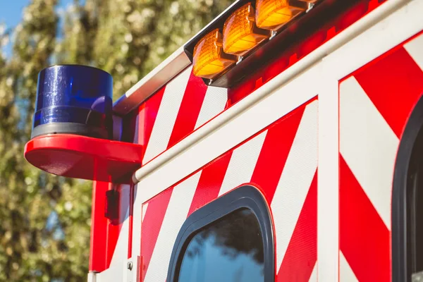 Blauw knipperend licht op een rode ambulance — Stockfoto