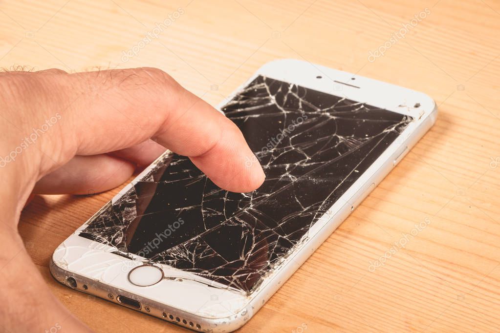 Paris, FRANCE - August 26, 2017: A man holds in his hand an iphone 6S of Apple Inc. whose screen is broken as a result of a violent fall