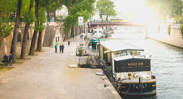 Tourists stroll along the Seine beside the barges in Paris, — Stock Photo, Image