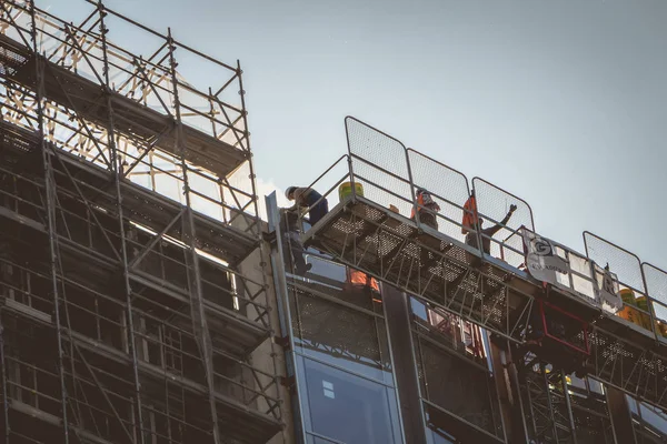 Trabalhadores que trabalham na construção de novos edifícios em — Fotografia de Stock