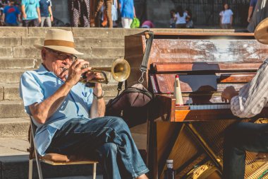 C önünde turistler için piyanist ve trompet çalar oynar