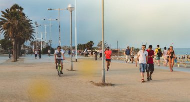 adam bir bisiklet ile Barcelona beach üzerinde gidiyor