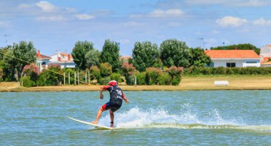 Wakeboarder rakamlar yapmak için gölde sarf