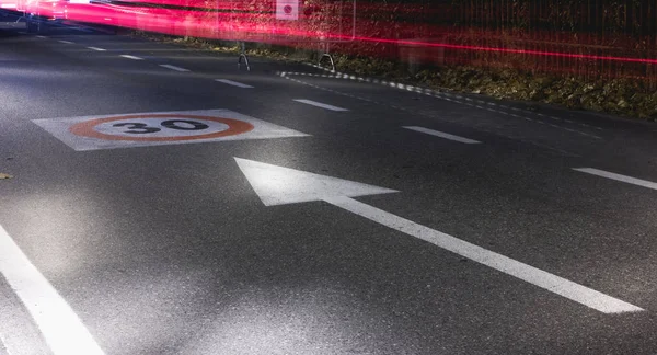 Sinal de limite de velocidade numa estrada de asfalto à noite — Fotografia de Stock