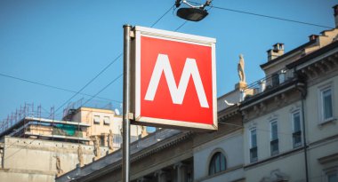 Bir metro istasyonunun girişini gösteren bir tabelanın yakın çekimi.