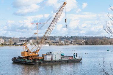 Floating construction barge with a crane on the Garonne river
