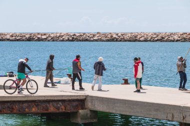 Fishermen by the sea coming together to enjoy the good weather i