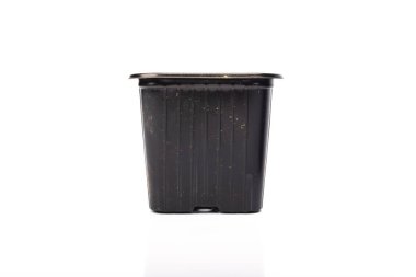 Stüdyoda beyaz arka planda baharı bekleyen siyah plastik bahçe kovası kullanılmış.