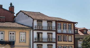 Guimaraes, Portekiz - 10 Mayıs 2018: Turistlerin bahar günü ziyaret ettiği tarihi şehir merkezinin küçük sokaklarının mimari ayrıntıları