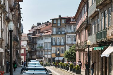 Guimaraes, Portekiz - 10 Mayıs 2018: Turistlerin bahar günü ziyaret ettiği tarihi şehir merkezinin küçük sokaklarının mimari ayrıntıları
