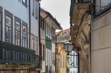 Guimaraes, Portekiz - 10 Mayıs 2018: Turistlerin bahar günü ziyaret ettiği tarihi şehir merkezinin küçük sokaklarının mimari ayrıntıları