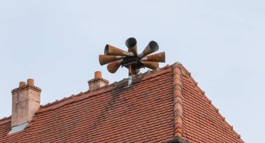 Siren alert to populations on the roof of a house in the city center clipart