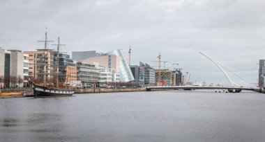Dublin, İrlanda - 12 Şubat 2019: 3 direkli yelkenli Jeanie Johnston ve Samuel Beckett köprüsünün kopyasıyla şehir merkezinde Liffey Nehri manzarası